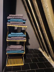 a stack of towels on a yellow rack in a room at Rooftop apartment with 60m terrace overlooking the cathedral in Antwerp