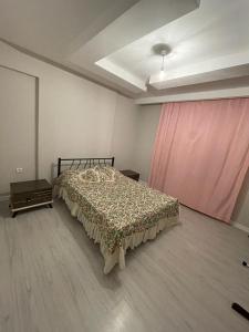 een slaapkamer met een bed en een roze gordijn bij Sırel Plaza in Nigde