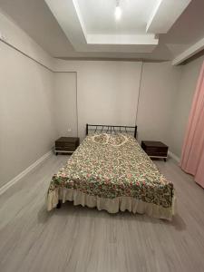 een slaapkamer met een bed met een deken erop bij Sırel Plaza in Nigde