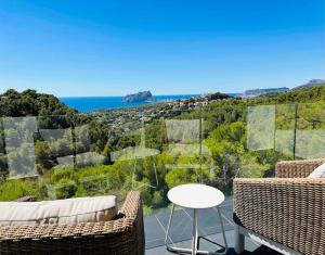 a balcony with two chairs and a table and the ocean at Moonlit BB Spa Art boutique Cab in Teulada