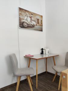 una mesa con dos sillas y una foto de un scooter en Beautiful apartment near the centre, en Viena