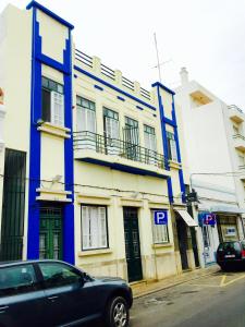 a blue and white building with a blue door at Guest House Sao Filipe in Faro