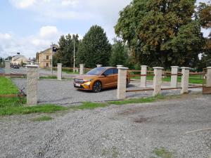 an orange car parked next to a fence at Apartmán Šumperk in Šumperk