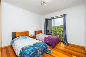 a bedroom with a bed and a large window at Vila Sol in Prazeres