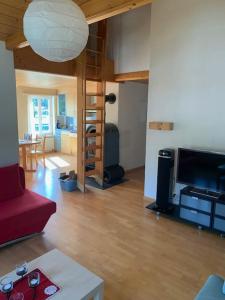 a living room with a red couch and a loft bed at Dachwohnung Zentrum Unterwasser in Unterwasser