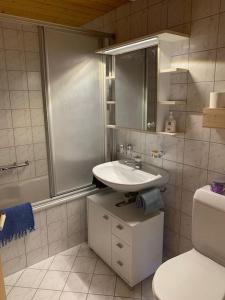 a white bathroom with a sink and a toilet at Dachwohnung Zentrum Unterwasser in Unterwasser
