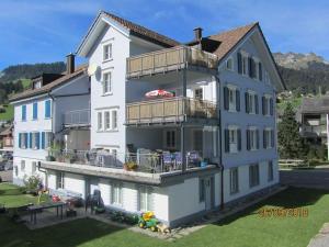 Großes weißes Gebäude mit Balkon in der Unterkunft Dachwohnung Zentrum Unterwasser in Unterwasser