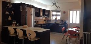 a kitchen with blue cabinets and a table and chairs at villa strati in Nafplio