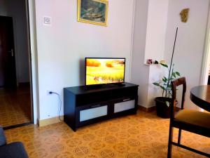 a flat screen tv sitting on a black stand in a living room at Apartment Tea 1 in Okrug Donji