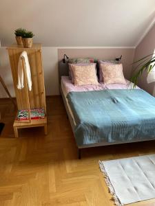 een slaapkamer met een bed en een houten vloer bij Apartament pod Dębami in Polanica-Zdrój