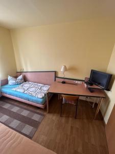 Zimmer mit einem Bett und einem Schreibtisch mit einem Computer in der Unterkunft Pension Sachsens Einkehr in Leipzig