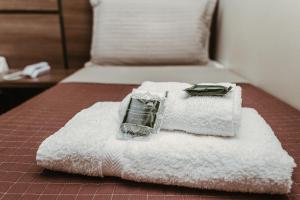 Una cama con toallas y un bolso encima. en Pousada Valle Verde, en Cabo Frío