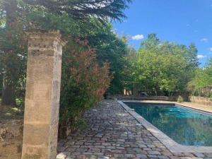 a stone walkway next to a swimming pool at Buisson gîte et chambre d'hôte in Laruscade