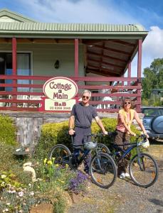 a man and woman standing with their bikes in front of a building at Cottage on Main in Franklin