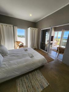 a bedroom with a large bed with a view of the ocean at Mirage-Beach Apartment in St Helena Bay