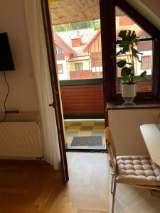 een deur naar een kamer met een tafel en een plant bij Apartament pod Dębami in Polanica-Zdrój