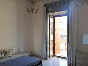 een slaapkamer met een bed en een grote glazen schuifdeur bij John Mary House in Catania