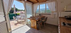 a kitchen and dining room with a table and a balcony at Apartmani Dutković in Vrboska