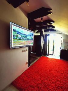 a living room with a red carpet and a flat screen tv at Appartement Cozy La Mansarda (Attic) in Miroslava