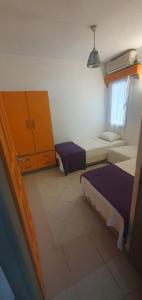 a small room with two beds and a dresser at Şahin Apart in Bodrum City