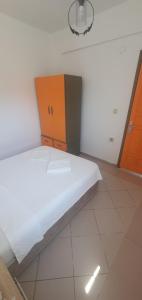 een wit bed in een kamer met een kast bij Şahin Apart in Bodrum City