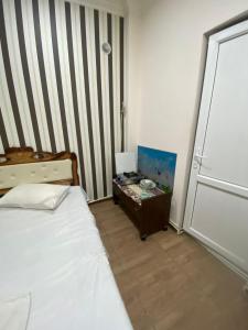 een slaapkamer met een bed, een tafel en een deur bij Cozy Suit with pool in Jerevan
