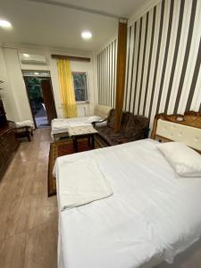 a bedroom with a white bed and a living room at Cozy Suit with pool in Yerevan