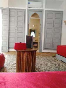 a room with white doors and a desk with a laptop at Riad L'Arganier in Marrakech