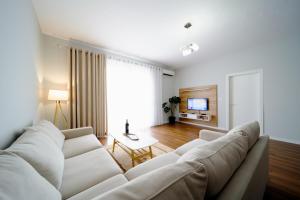 sala de estar con sofá blanco y mesa en Apartamente Tirana en Tirana