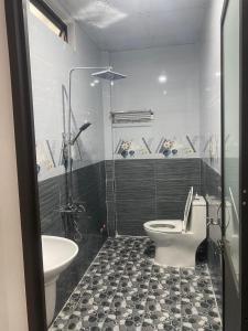 a bathroom with a toilet and a sink at Nhà nghỉ Hoàng Gia in Ba Tơ