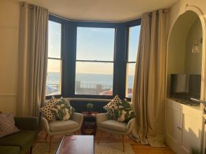 a living room with a large window with a view of the ocean at King Palm Apartment at Sea View Terrace, Margate. in Kent