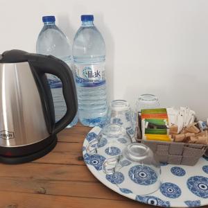 a tea kettle and glasses and bottles of water on a table at Sabor Residence in North Nicosia