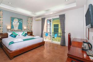 Un dormitorio con una cama grande y un balcón. en SawasdeeCiao Patong Guesthouse, en Patong Beach