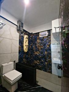 a bathroom with a toilet and a wall with a face on it at Rock Lake Villa in Vagamon +61 photos