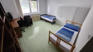 Cette chambre comprend deux lits, un bureau et un ordinateur. dans l'établissement Apartmán č1 Bojnice 450m od centra, à Bojnice