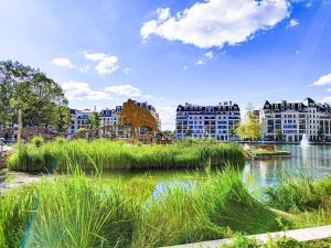 miasto z wysoką trawą, budynkami i rzeką w obiekcie SweetMoulinHome 5 km from Paris w mieście Le Plessis-Robinson