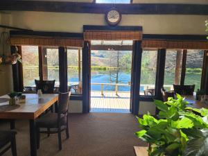a dining room with a table and a clock on the wall at Cleopatra Mountain Farmhouse in Mooiriver