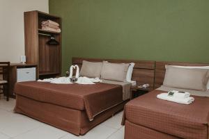 ein Hotelzimmer mit 2 Betten und Handtüchern darauf in der Unterkunft Pousada Valle Verde in Cabo Frio