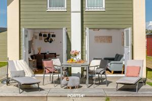 a patio with chairs and a table and a dining room at Nordic Lodge in Büsum