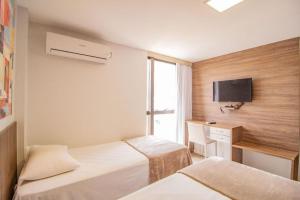 a hotel room with two beds and a television at TaguaPark Hotel in Taguatinga