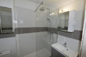 a white bathroom with a shower and a sink at Joli studio à 5min de la plage à Palavas in Palavas-les-Flots
