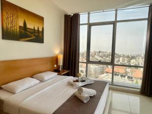 a bedroom with a large bed and a large window at Caesar Hotel Ramallah in Ramallah