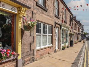 a street in a town with buildings and flowers at Glencoe House in Wooler