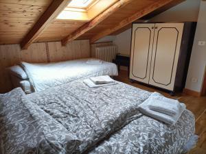 Pokój na poddaszu z 2 łóżkami i lodówką w obiekcie Resort CuraLibera w mieście Ronzone