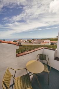 a table and chairs on a balcony with a view of the ocean at Casa do Riacho in Nordeste