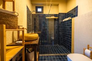 W łazience znajduje się prysznic wyłożony niebieskimi kafelkami i umywalka. w obiekcie Void Hotel Urla w mieście Urla