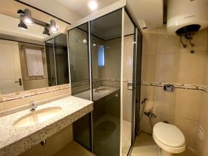 a bathroom with a shower and a toilet and a sink at Hotel Renty Beach in Encarnación