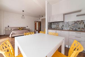 una cucina e un soggiorno con tavolo e sedie bianchi di B&B Dimora Belvedere a Barisciano