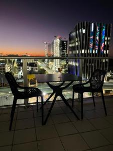 una mesa y 2 sillas en un balcón por la noche en ANTEA apartments Embassy free parking en Adelaida