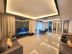 sala de estar con sofá y TV en Impiana Lakeview Villa - Contactless Check In en Kluang